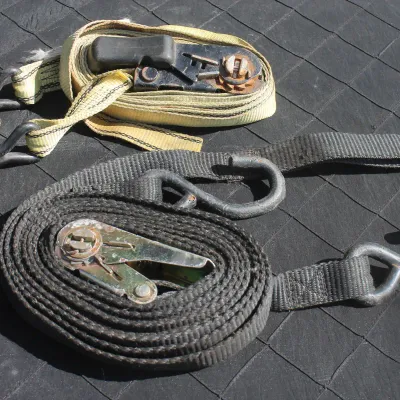 Sale Photo Thumbnail #71: Pair of heavy-duty ratchet tie-down straps with S-hooks, showing light wear and minor rust on hardware.