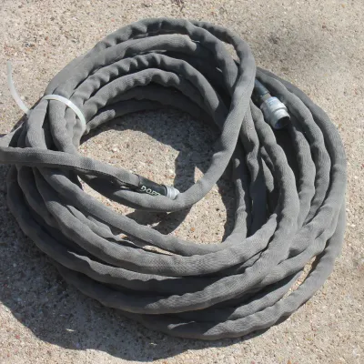 Sale Photo Thumbnail #39: Coiled grey Zero-G woven fabric garden hose secured with a zip tie, resting on concrete.
