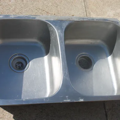 Sale Photo Thumbnail #2: Stainless steel double-basin undermount kitchen sink showing light surface wear and residue around the rim.