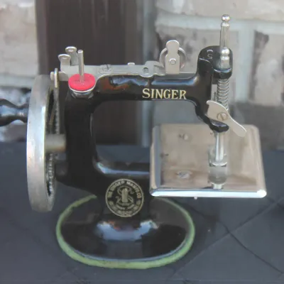 Sale Photo Thumbnail #32: Vintage Singer hand-crank miniature sewing machine, cast iron with gold lettering and silver-tone hardware.