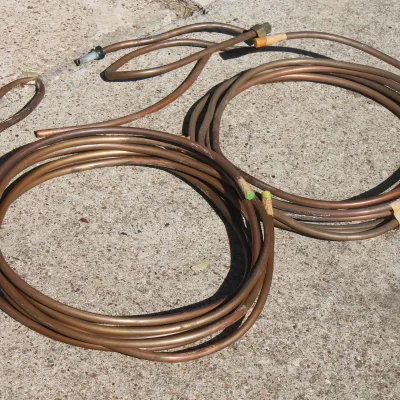 Sale Photo Thumbnail #47: Coils of flexible copper tubing with brass fittings, suitable for plumbing or refrigeration projects.
