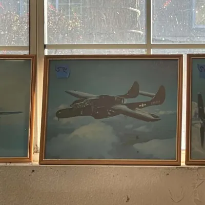 Sale Photo Thumbnail #57: Framed aviation print depicting a military aircraft in flight, displayed in a simple wooden frame alongside other prints.