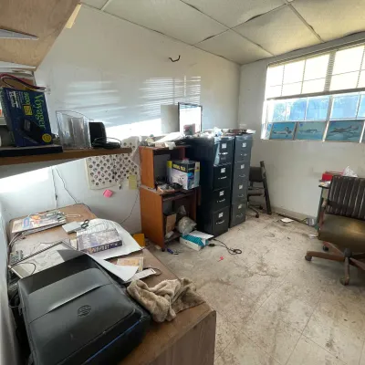 Sale Photo Thumbnail #54: Cluttered office room featuring wooden desks, black metal filing cabinets, vintage office chairs, computer equipment, and assorted media.