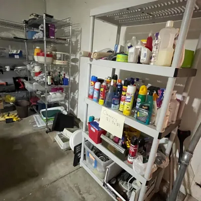 Sale Photo Thumbnail #77: Assorted household cleaners, spray cans, and automotive products arranged on multi-tiered plastic and wire shelving units.