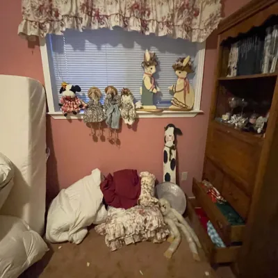 Sale Photo Thumbnail #91: Collection of country-style decorative items, featuring plush dolls, wooden bunny cutouts, and a painted wooden cow board set in a room with a floral valance.