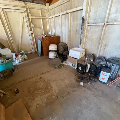 Sale Photo Thumbnail #36: Storage shed area containing space heaters, Dish Network satellite dishes, small appliances, and assorted household supplies.
