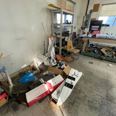 Sale Photo Thumbnail #22: Assorted model airplane parts, kits, and workshop equipment, including SIG Kadet Senior RC plane components, plastic shelving, and tool benches.