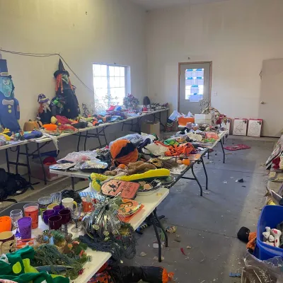 Sale Photo Thumbnail #15: Large collection of Halloween decorations, costumes, glassware, and seasonal items arranged on folding tables.