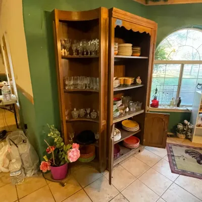 Sale Photo Thumbnail #96: Two-piece wooden hutch and corner display cabinet set filled with glassware, dishes, and kitchenware.