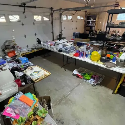 Sale Photo Thumbnail #68: Garage sale setup featuring folding tables loaded with various household goods, kitchenware, small appliances, glassware, and decor items.