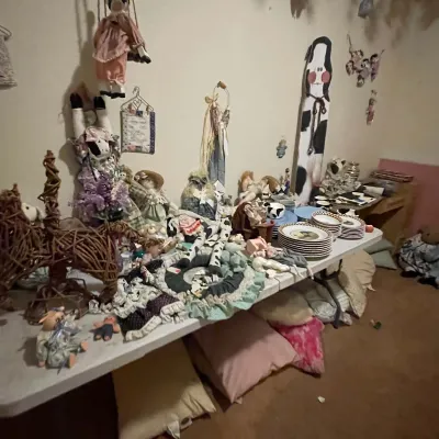 Sale Photo Thumbnail #87: Collection of country-style decor, including wicker sculptures, fabric dolls, porcelain collectibles, and stacked ceramic tableware.