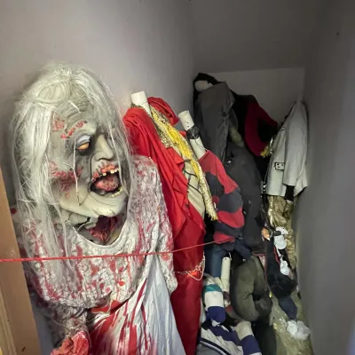 Sale Photo Thumbnail #16: Collection of life-size Halloween animatronics, mannequins, and horror costumes stored in a closet, including a bloody ghoul bride.