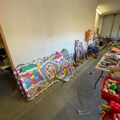 Sale Photo Thumbnail #14: Large collection of vintage painted wooden Christmas lawn cutouts leaning against a garage wall.