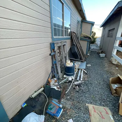 Sale Photo Thumbnail #27: Assorted outdoor utility items and pool maintenance equipment leaning against a residential building.