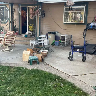 Sale Photo Thumbnail #50: Patio assortment featuring a blue rollator walker, a treadmill, pet carriers, patio seating, and small plastic step stools.