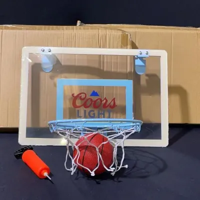 Sale Photo Thumbnail #89: Coors Light over-the-door mini basketball hoop set featuring a clear backboard, small basketball, hand pump, and original packaging.
