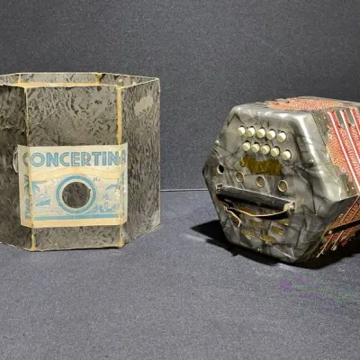 Sale Photo Thumbnail #33: Vintage hex-shaped concertina accordion featuring a grey pearloid finish and red pattern bellows, shown with its original fitted cardboard box.