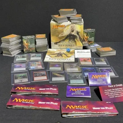 Sale Photo Thumbnail #70: Collection of Magic: The Gathering cards and accessories, featuring an Avacyn Restored Fat Pack box, several top-loaded rare cards, bulk stacks, deck boxes, and player guides.