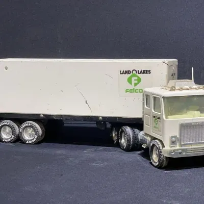 Sale Photo Thumbnail #90: Vintage Nylint Land O' Lakes Felco GMC semi-truck and trailer toy, featuring a pressed steel construction with original decals and play wear.