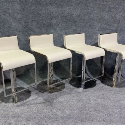 Sale Photo Thumbnail #88: Set of four modern bar stools featuring off-white leather upholstery and polished chrome pedestal bases.