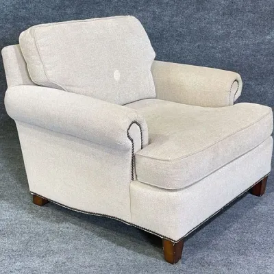 Sale Photo Thumbnail #38: Traditional upholstered armchair in beige fabric with rolled arms and nailhead trim accents.