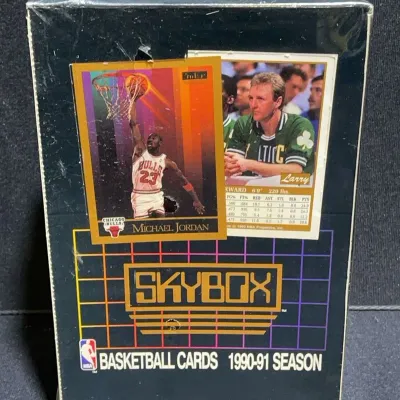 Sale Photo Thumbnail #60: Sealed factory box of 1990-91 SkyBox NBA basketball trading cards featuring Michael Jordan and Larry Bird graphics on the outer packaging.