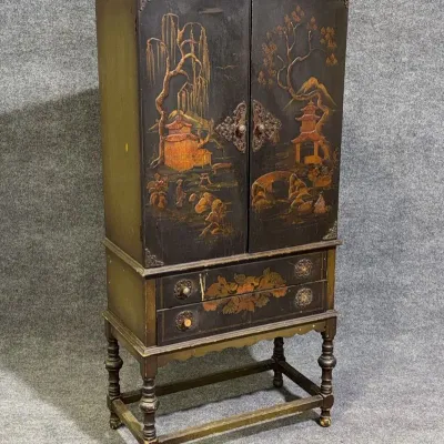 Sale Photo Thumbnail #12: Vintage Asian-inspired chinoiserie cabinet on turned legs, featuring hand-painted landscape scenes, brass hardware, and two lower drawers.