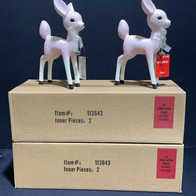 Sale Photo Thumbnail #96: Pair of MerryBrite pastel pink fawn deer figurines with silver bow collars and jingle bells, displayed on cardboard boxes.