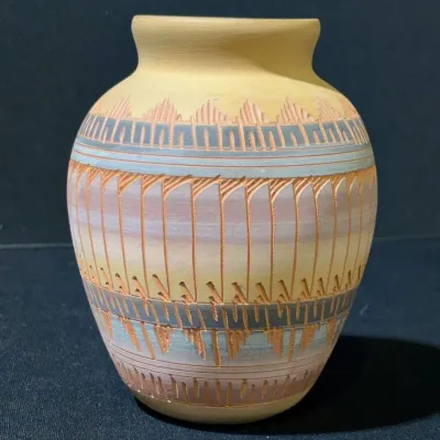Sale Photo Thumbnail #40: Southwestern-style pottery vase featuring carved geometric patterns and pastel sgraffito details over a light yellow matte finish.