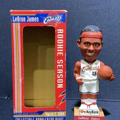 Sale Photo Thumbnail #13: LeBron James Cleveland Cavaliers rookie season collectible bobblehead from March 3, 2004, shown with its original promotional display box.