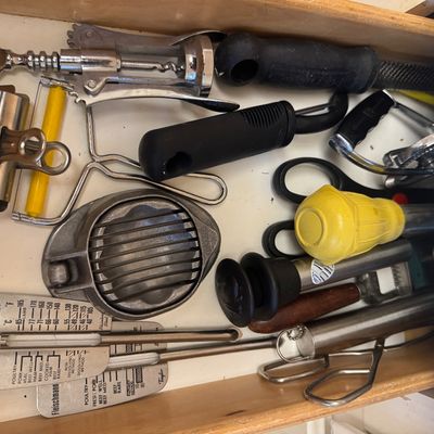 Sale Photo Thumbnail #29: Assorted vintage and modern kitchen utensils stored in a drawer, including a winged corkscrew, egg slicer, vegetable peeler, and Taylor meat thermometers.