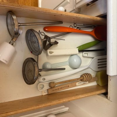 Sale Photo Thumbnail #28: Assorted kitchen utensils housed in a wooden drawer, including cooking thermometers, measuring spoons, spatulas, and a Williams-Sonoma wooden honey dipper.