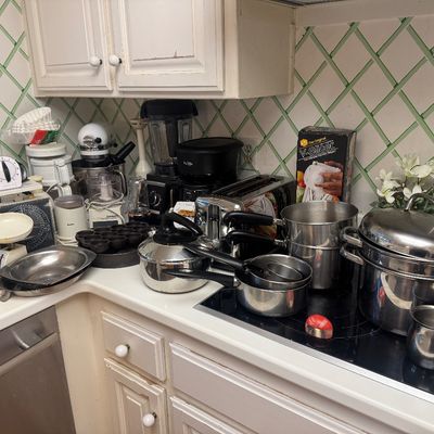 Sale Photo Thumbnail #21: Collection of kitchen small appliances and cookware, including a white KitchenAid stand mixer, a blender, coffee makers, stainless steel pots, and a vintage kitchen scale.