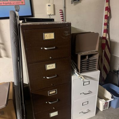 Sale Photo Thumbnail #72: Vintage dark brown four-drawer metal filing cabinet alongside a smaller two-drawer white filing cabinet and office storage accessories.