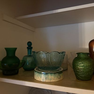 Sale Photo Thumbnail #42: Collection of vintage glass tableware, including a teal pressed glass bowl on a ceramic stand, green art glass vases, and an amber glass bottle.