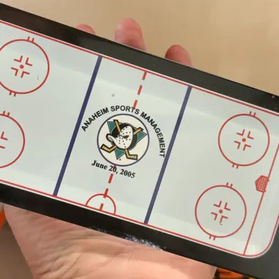 Sale Photo Thumbnail #2: Commemorative Anaheim Sports Management hockey rink glass paperweight or plaque dated June 20, 2005, featuring the Mighty Ducks logo.