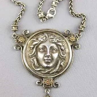 Sale Photo Thumbnail #13: Vintage-style sterling silver statement necklace featuring a detailed Medusa head medallion and a teardrop-shaped green glass or gemstone pendant on a woven chain.