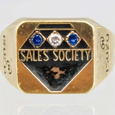 Sale Photo Thumbnail #16: Vintage Isuzu 'Sales Society' corporate award signet ring featuring black enamel inlay with clear and blue synthetic stone accents.