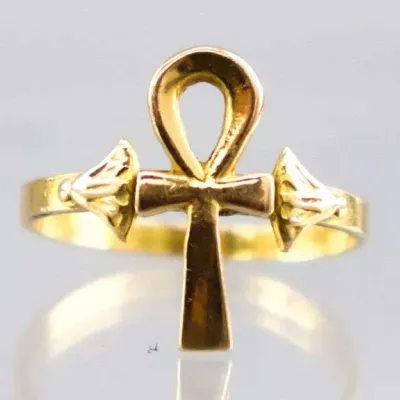 Sale Photo Thumbnail #11: Gold-tone Egyptian Revival ankh ring featuring a central ankh cross flanked by detailed lotus motifs.