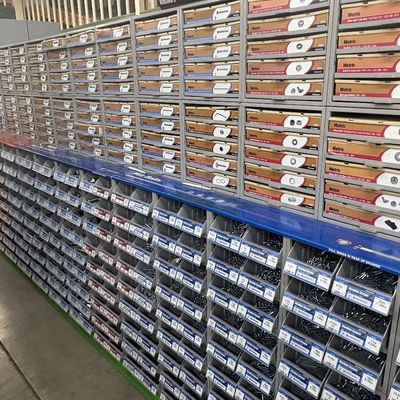 Sale Photo Thumbnail #67: Large multi-tier hardware display system featuring Hillman brand metric and standard nuts, bolts, screws, and fasteners stored in organized plastic bins and drawers.