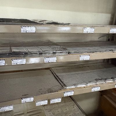 Sale Photo Thumbnail #37: Selection of metal and wooden home improvement components organized on multi-tiered industrial shelving, including tin ceiling panels and stemware racks.