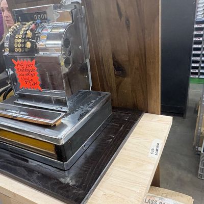 Sale Photo Thumbnail #60: Vintage 1943-1944 chrome cash register mounted on a dark wooden base, displaying visible wear to the finish.