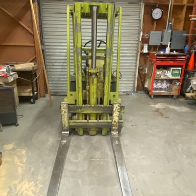 Sale Photo Thumbnail #2: Vintage chartreuse Clark industrial forklift featuring heavy-duty forks and a hydraulic lift mast.