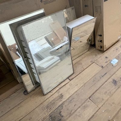 Sale Photo Thumbnail #28: Selection of modern wall mirrors and bathroom medicine cabinets leaning against storage boxes.