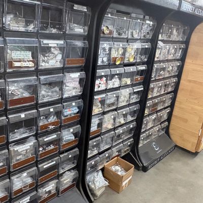 Sale Photo Thumbnail #65: Retail display racks filled with clear plastic tilt bins containing various cabinet hardware and small fittings, including Jeffrey Alexander branded units.