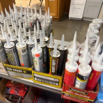 Sale Photo Thumbnail #9: Large assortment of Titebond caulks and construction adhesives arranged in original display boxes on a shelf.
