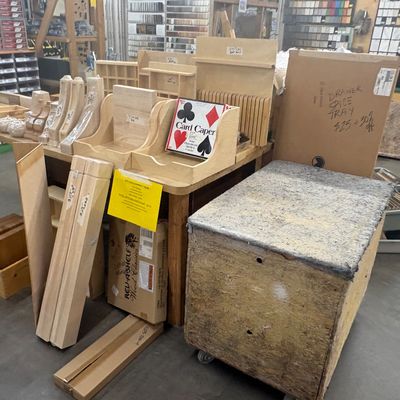 Sale Photo Thumbnail #58: Assorted woodworking supplies, unfinished wooden organizer trays, furniture legs, and a padded rolling cart.