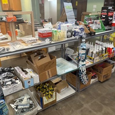 Sale Photo Thumbnail #19: Metal shelving units filled with various hardware, workshop supplies, door hinges, clipboards, and safety equipment.