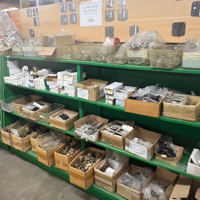 Sale Photo Thumbnail #83: Large collection of assorted door hardware and hinges organized in boxes and bins on green utility shelving.