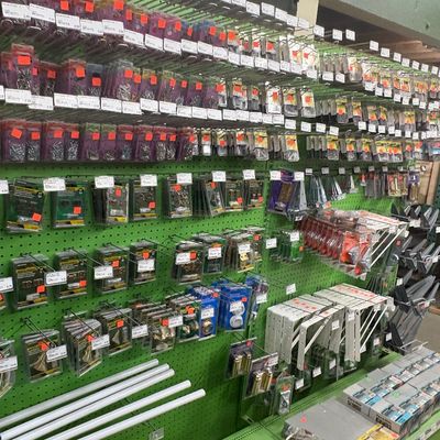 Sale Photo Thumbnail #73: Wall display unit filled with various packaged hardware items, including hinges, shelf brackets, and fasteners.